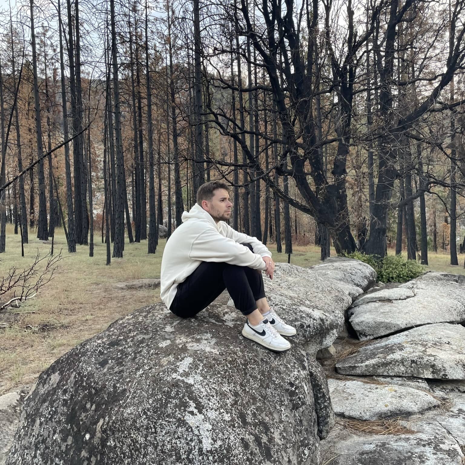 Nicolas seat on rock in forest